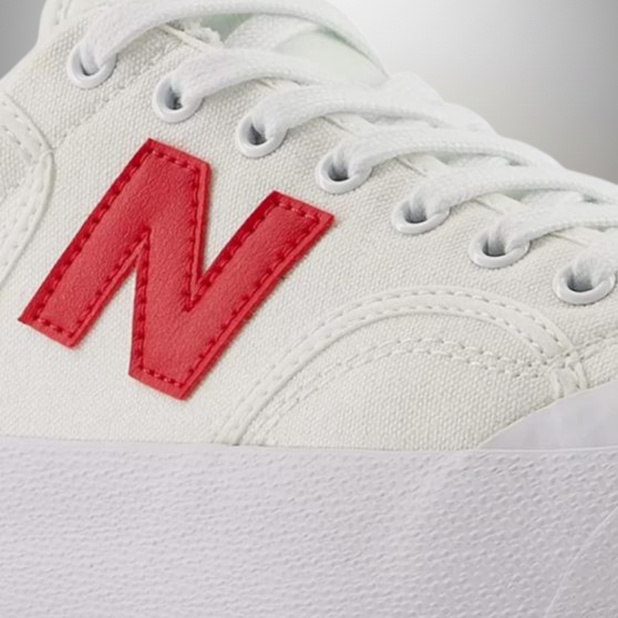 Zapatillas New Balance 100 blanco y rojo talla 43 detalle del logo y materiales